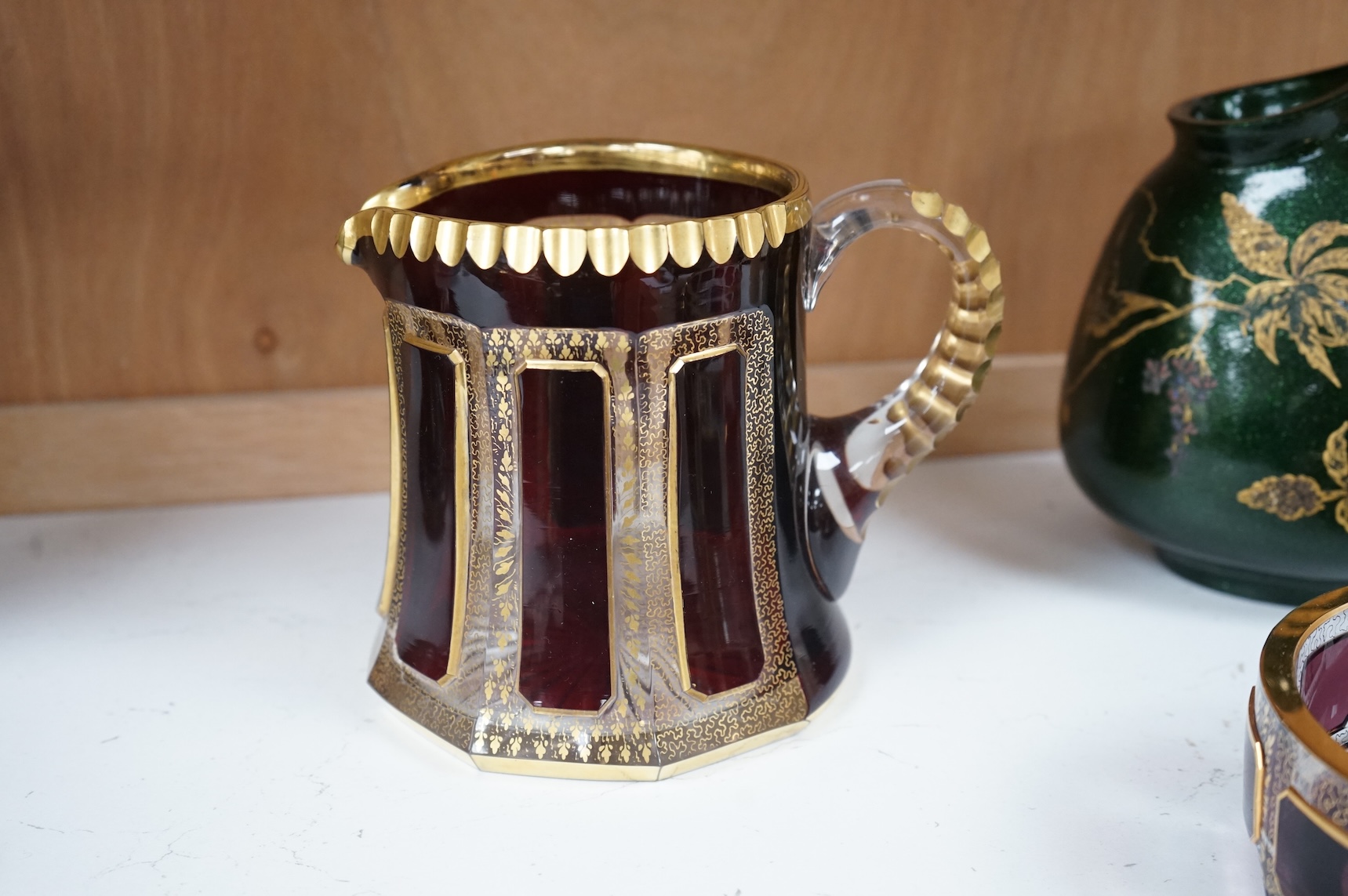 Three pieces of Bohemian and Austrian glassware comprising two jugs and an ashtray, largest 17cm high
